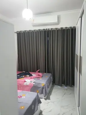 a bedroom with two twin beds and curtains at جوليانا بيتش ريزورت in Hurghada