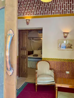 a living room with a chair and a bed at El Juneina Villas in Luxor