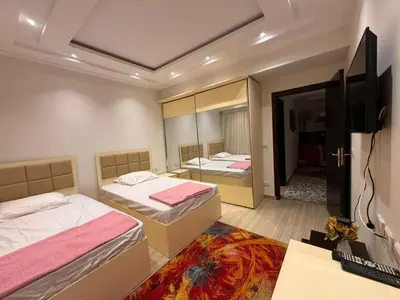 a bedroom with two beds and a flat screen tv at Touristic centre beach1 in Hurghada