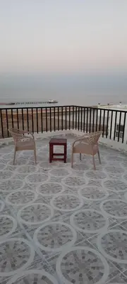 two benches and a table on the beach at Royal view suite in Hurghada