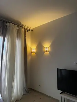 a bedroom with a white curtain and a television at Cozy 1BR Retreat in Gouna in Hurghada