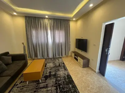 a living room with a couch and a tv at شاليه ميراج باي ريزورت in Hurghada