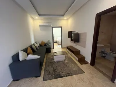 a living room with a blue couch and a tv at شاليه ميراج باي ريزورت in Hurghada