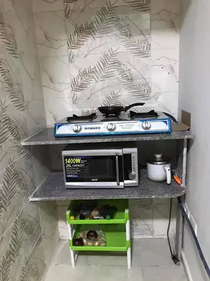 a kitchen with a stove and a microwave on a shelf at room2 a room in Hostel of 4 rooms in Hurghada