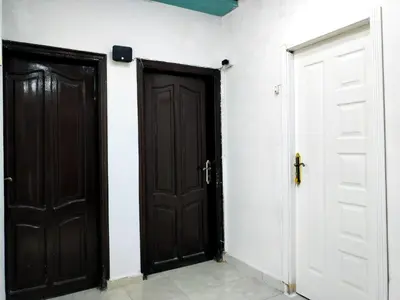two black doors in a room with white walls at room1 a room in Hostel of 4 rooms in Hurghada