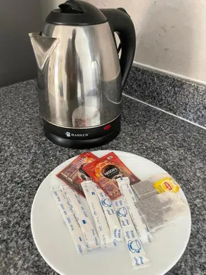 a plate with a tea kettle and a packet of sugar at Bayt Hassan S19 - Super spacious roof top One Bedroom apartment in Hurghada