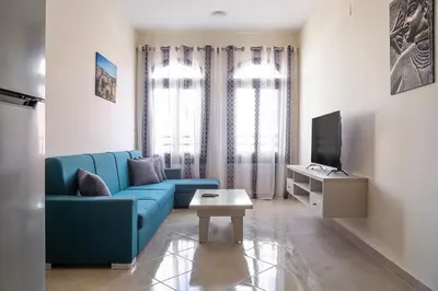 a living room with a blue couch and a tv at Bayt Hassan A11 - 2 bedrooms spacious appartment in Hurghada