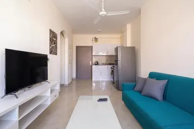 a living room with a blue couch and a flat screen tv at Bayt Hassan A11 - 2 bedrooms spacious appartment in Hurghada