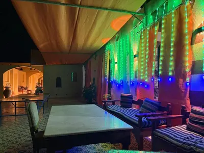 a room with a table and chairs and colorful lights at Nile Compound Garden in Al Aqālitah