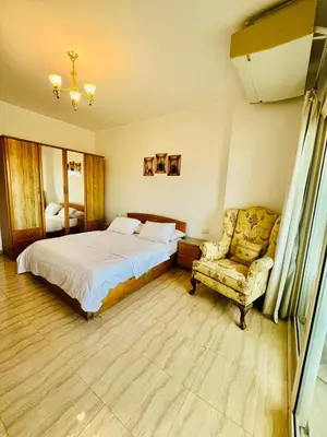 a bedroom with a bed and a chair at touristic centre Andalusia in Hurghada