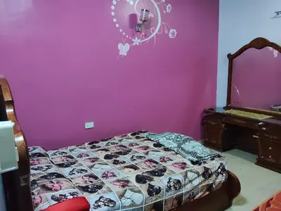 a bedroom with a bed and a purple wall at Sea view in Quseir