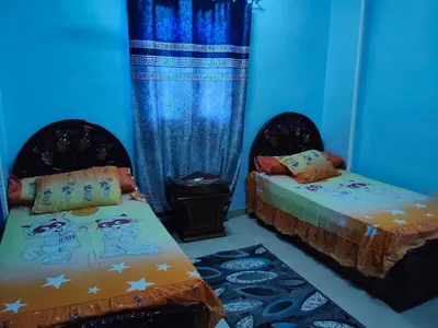 two beds in a room with blue walls at Sea view in Quseir