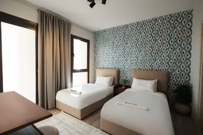 a hotel room with two beds and a patterned wall at Shedwan Sky Loft Rooftop Escape with Pool View in Hurghada