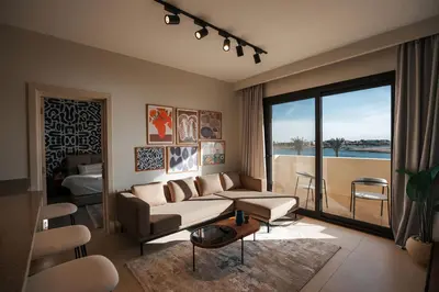 a living room with a couch and a large window at Shedwan Sky Loft Rooftop Escape with Pool View in Hurghada