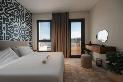 a bedroom with a large white bed and a desk at Shedwan Sky Loft Rooftop Escape with Pool View in Hurghada
