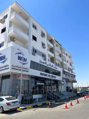 a white building with a car parked in front of it at Poseidon Apartments in Hurghada