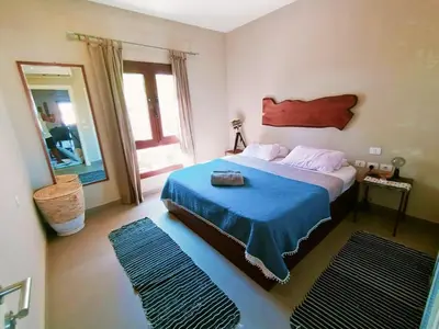a bedroom with a bed with a blue blanket and a mirror at Cozy Lagoon Escpae-1Bdr Retreat in Hurghada