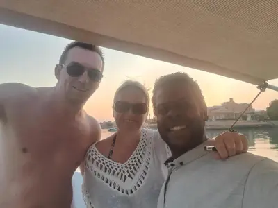 two men and a woman posing for a picture on a boat at Habob Nubian Guest House in Aswan
