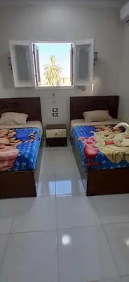 two beds in a room with a window at Habob Nubian Guest House in Aswan