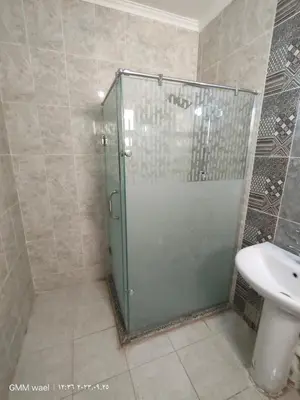 a shower with a glass door in a bathroom at مدينة ناصر غرب أسيوط