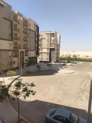a car parked in a parking lot next to buildings at مدينة ناصر غرب أسيوط