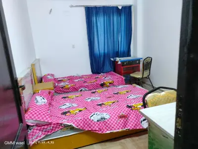 a bedroom with a bed with a pink comforter at مدينة ناصر غرب أسيوط