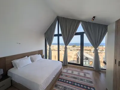a bedroom with a bed and a large window at Modern 2BR Somabay Seaview Villa Free Beach & Pool in Hurghada