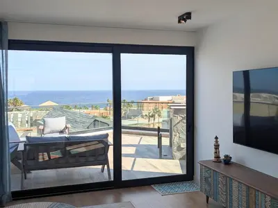 a living room with sliding glass doors with a view of the ocean at Modern 2BR Somabay Seaview Villa Free Beach & Pool in Hurghada