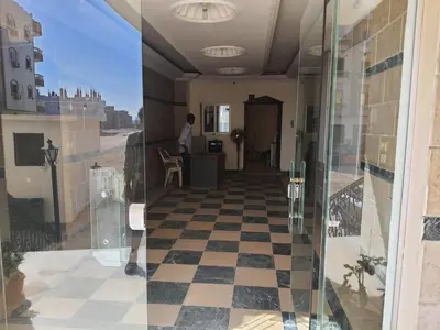 a man standing in a room with a checkered floor at Oasis compound in Hurghada