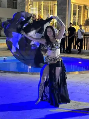 a woman dancing on a stage in front of a pool at Hurghada Fanader Bay Lever111 in Hurghada
