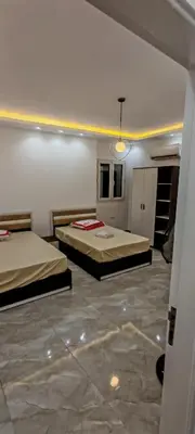 a room with two beds in a room with a stone floor at فيلا بجوار سينزو مول in Hurghada