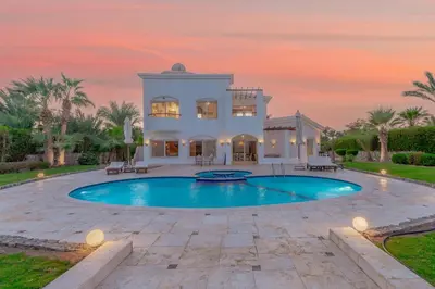 a villa with a swimming pool at sunset at Beautiful 4 BDR Villa With Private Pool in Hurghada