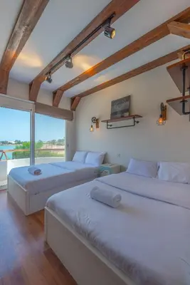 two beds in a room with a large window at Beautiful 4 BDR Villa With Private Pool in Hurghada