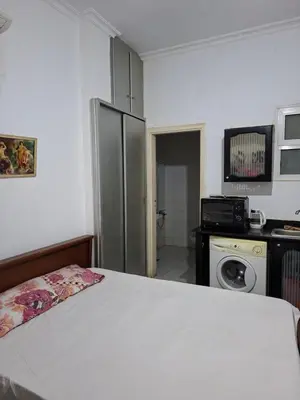 a room with a bed and a refrigerator at Lotos studio in Hurghada