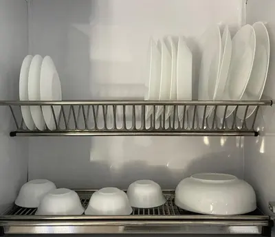 a shelf with white plates and bowls in a kitchen at Bayt Hassan A13 - Superb 2 bedrooms in Hurghada