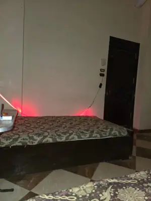 a bedroom with a bed with red lights on the wall at Golden home in Aswan
