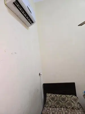 a small room with a bed and a ceiling fan at Golden home in Aswan