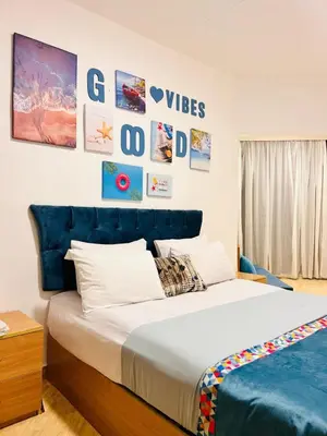 a bedroom with a large bed with a blue headboard at Hurghada Studios in Hurghada