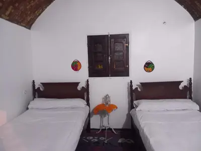 two beds in a room with white walls at Soul House in Jazīrat Fīlah