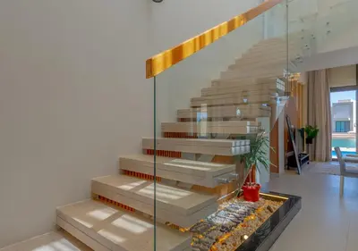 a staircase in a house with a glass wall at Breezy Lagoonfront Escape 3BR with Private Pool I Tawila El Gouna in Hurghada