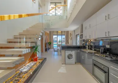 a large kitchen with stairs and a washing machine at Breezy Lagoonfront Escape 3BR with Private Pool I Tawila El Gouna in Hurghada