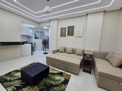 a living room with two couches and a kitchen at Sheraton - New & Stylish Flat in Hurghada