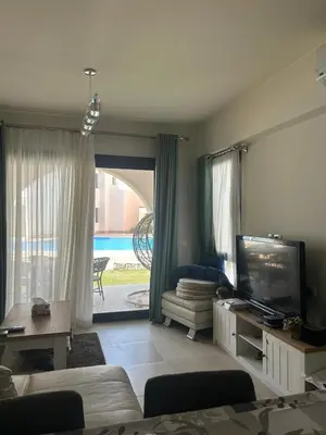 a living room with a couch and a tv and a living room with a view at Tranquil 3-Bedroom Holiday Home in Makadi Heights, Hurghada - Private Rooftop Pool, Lagoon and More in Hurghada