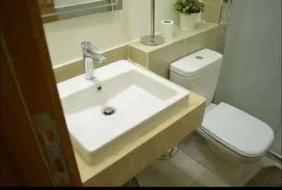 a bathroom with a white sink and a toilet at Tranquil 3-Bedroom Holiday Home in Makadi Heights, Hurghada - Private Rooftop Pool, Lagoon and More in Hurghada