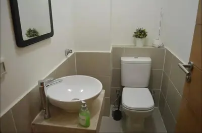 a bathroom with a white toilet and a sink at Tranquil 3-Bedroom Holiday Home in Makadi Heights, Hurghada - Private Rooftop Pool, Lagoon and More in Hurghada