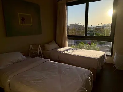 two beds in a hotel room with a window at Panoramic 2BR Apt-Free Pool And Lagoon Access At ElGouna in Hurghada