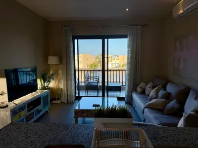 a living room with a couch and a television at Panoramic 2BR Apt-Free Pool And Lagoon Access At ElGouna in Hurghada