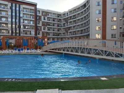 a swimming pool in front of a large apartment building at Tiba Golden Resort Hurghada in Hurghada