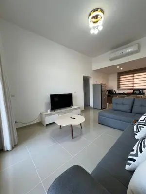 a living room with a blue couch and a tv at Luxury Stays in G-Cribs El Gouna in El Gouna