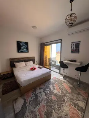 a bedroom with a bed and a table and chairs at Studio 511 imperial resort in Hurghada